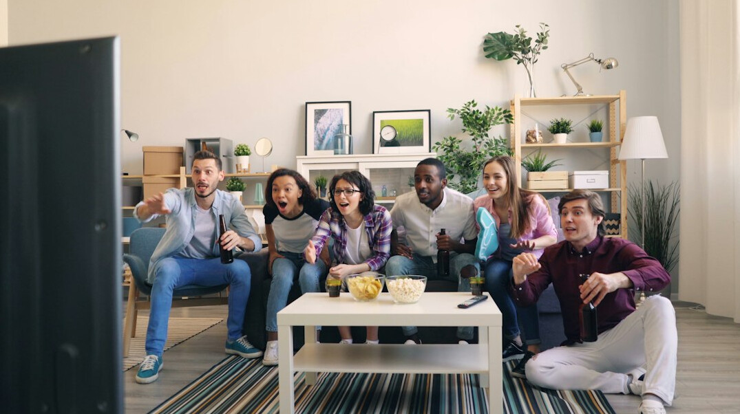 group of friends on couch watching tv
